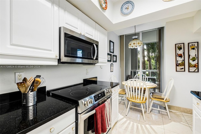 kitchen featuring white cabinetry, an inviting chandelier, pendant lighting, light tile patterned flooring, and appliances with stainless steel finishes