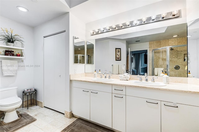 bathroom with tile patterned floors, vanity, toilet, and a shower with shower door