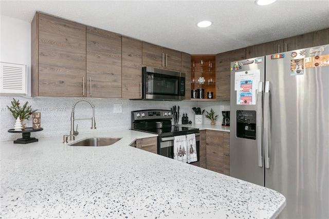 kitchen with decorative backsplash, sink, kitchen peninsula, and stainless steel appliances