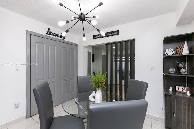 tiled dining room with a notable chandelier and a textured ceiling