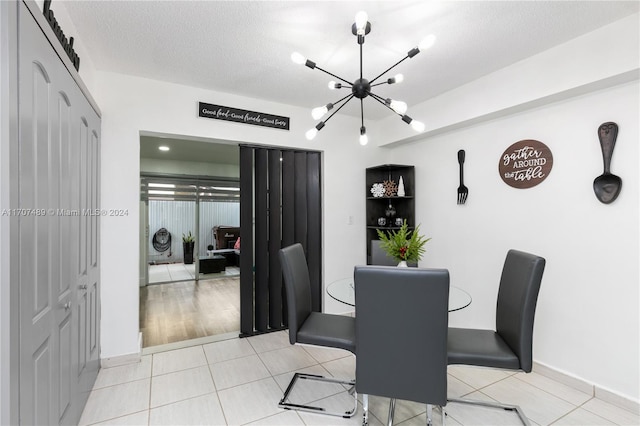 tiled dining room featuring a textured ceiling and an inviting chandelier