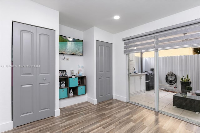 bedroom with sink, two closets, and light wood-type flooring