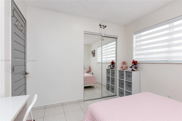 tiled bedroom with a closet