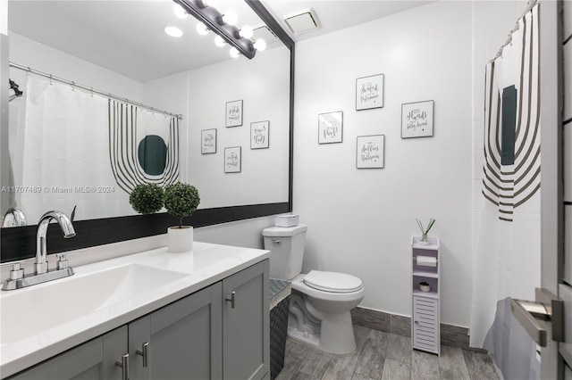 bathroom featuring hardwood / wood-style flooring, vanity, and toilet