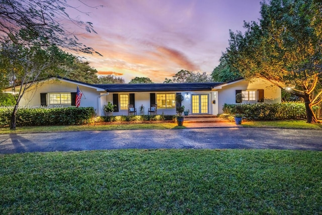 ranch-style home with a yard and french doors