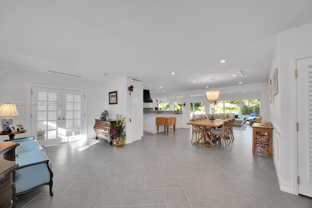 tiled living room featuring french doors and an inviting chandelier