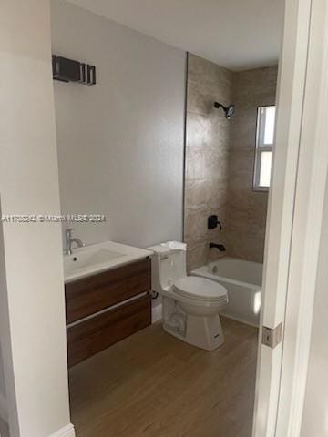 full bathroom featuring vanity, toilet, wood-type flooring, and tiled shower / bath combo