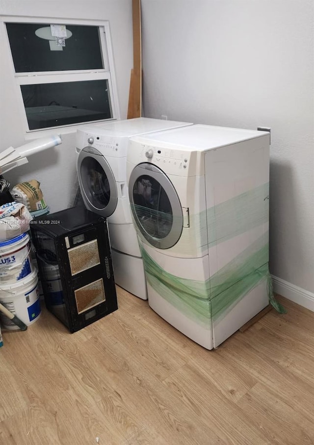 laundry room with light hardwood / wood-style floors and washing machine and clothes dryer