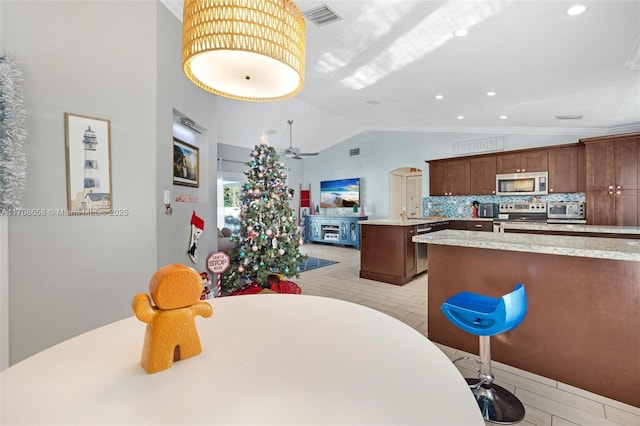 dining room featuring vaulted ceiling, ceiling fan, and light hardwood / wood-style flooring