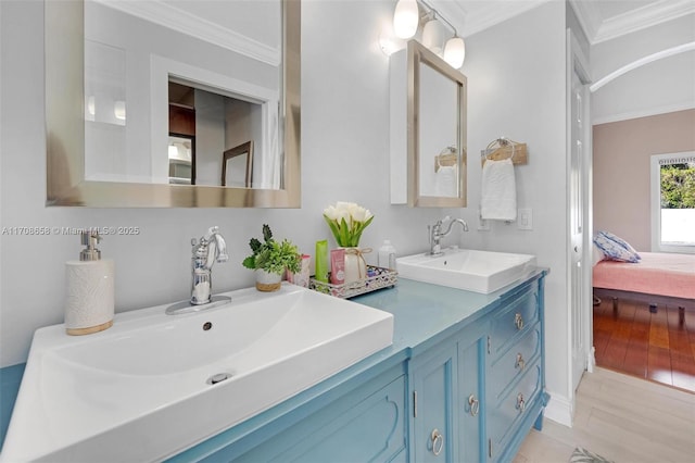 bathroom with hardwood / wood-style flooring, crown molding, and vanity