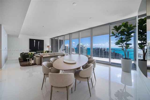 dining space featuring a water view and a wall of windows