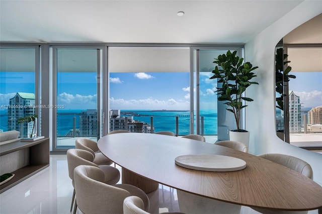 dining space featuring floor to ceiling windows and a water view