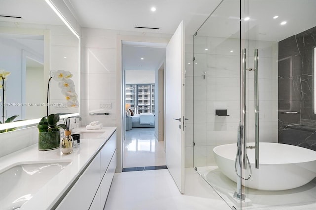 bathroom with vanity, tile walls, and separate shower and tub