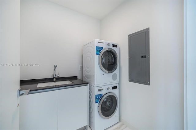 laundry room with stacked washer and dryer, cabinets, electric panel, and sink