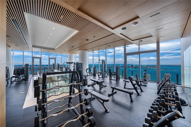 exercise room with expansive windows and a water view