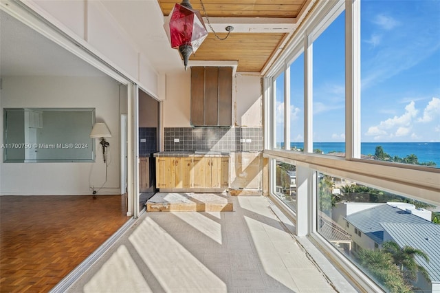 sunroom with a water view and wood ceiling