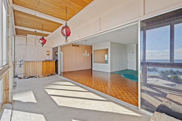 interior space with parquet floors, wood ceiling, and an inviting chandelier