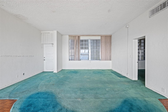 carpeted spare room featuring a textured ceiling