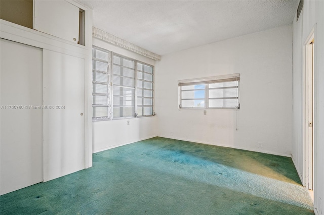 unfurnished bedroom with a closet, dark carpet, and a textured ceiling