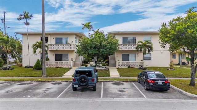 2072 NE 169th St Unit 10, North Miami Beach, FL 33162 - view of front of house with stucco siding, uncovered parking, and a front lawn