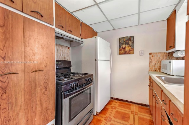 2072 NE 169th St Unit 10, North Miami Beach, FL 33162 - kitchen with stainless steel range with gas cooktop, white microwave, under cabinet range hood, backsplash, and a paneled ceiling