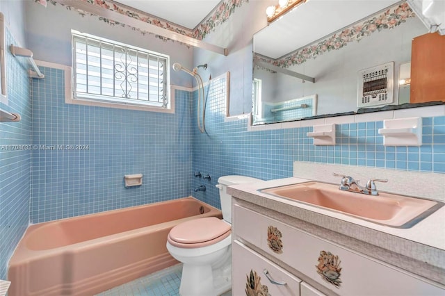 full bathroom with vanity, tiled shower / bath, tile patterned flooring, toilet, and tile walls