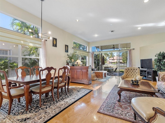 dining room featuring light hardwood / wood-style floors and ceiling fan with notable chandelier