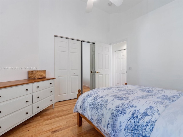 bedroom with a high ceiling, light wood-type flooring, a closet, and ceiling fan