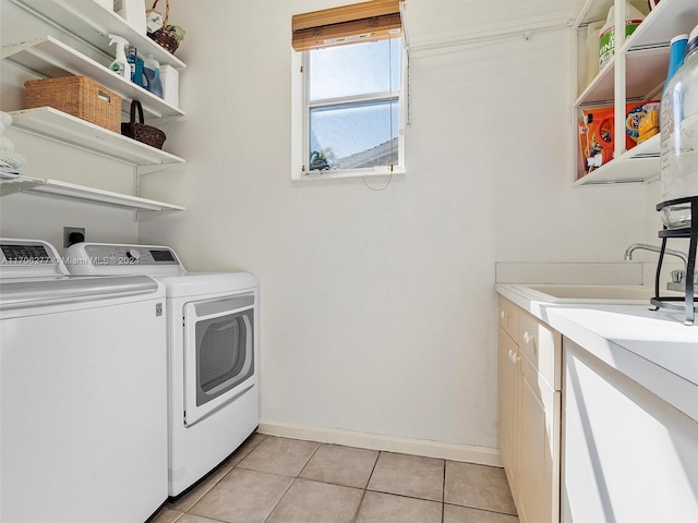 laundry area featuring separate washer and dryer, light tile patterned floors, and cabinets