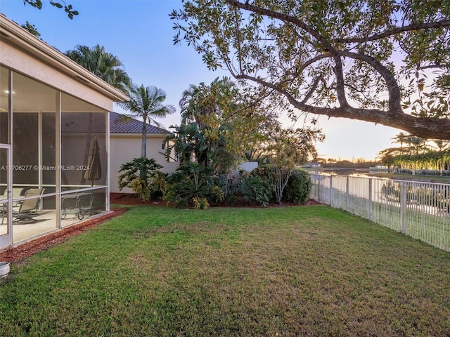 yard at dusk with a sunroom