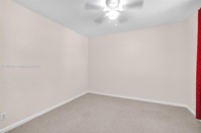 carpeted spare room featuring ceiling fan