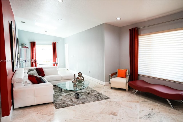 living room with a textured ceiling and vaulted ceiling