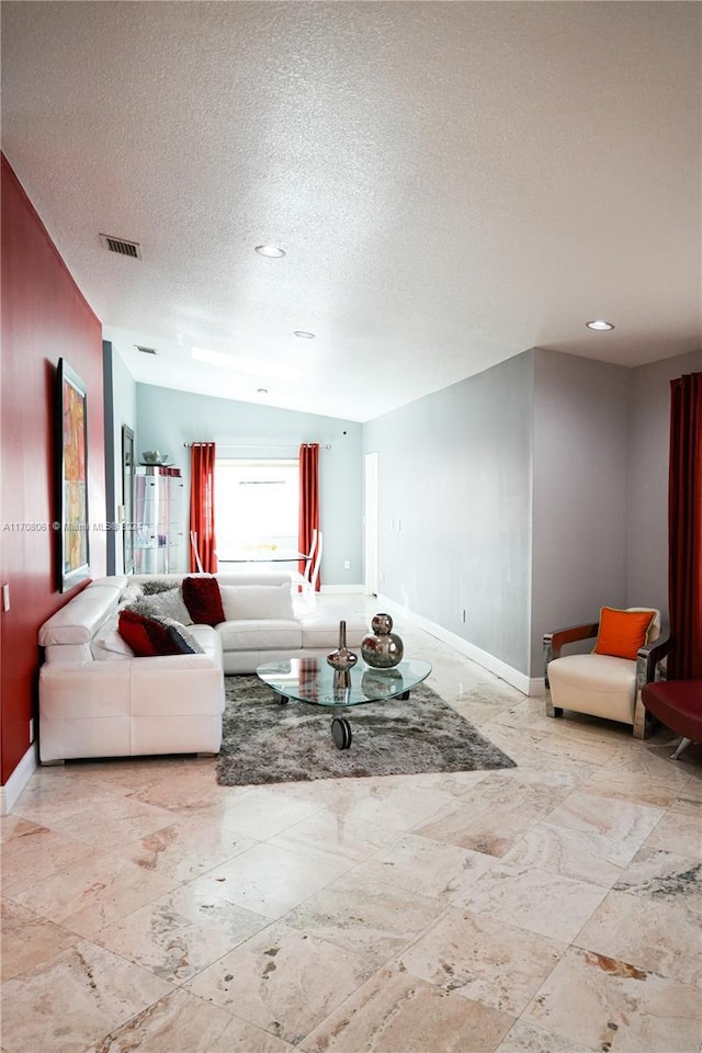 living room featuring a textured ceiling and vaulted ceiling