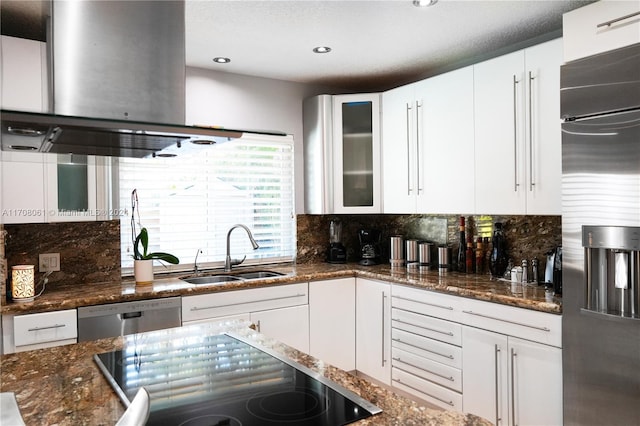 kitchen featuring white cabinets, sink, dark stone countertops, appliances with stainless steel finishes, and tasteful backsplash