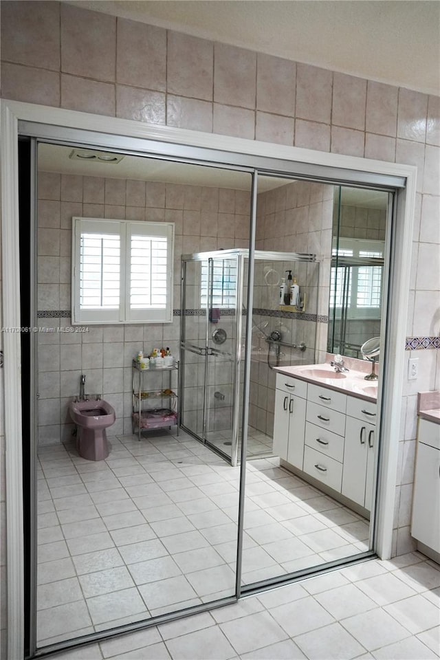 bathroom featuring vanity, a bidet, tile patterned flooring, tile walls, and a shower with shower door