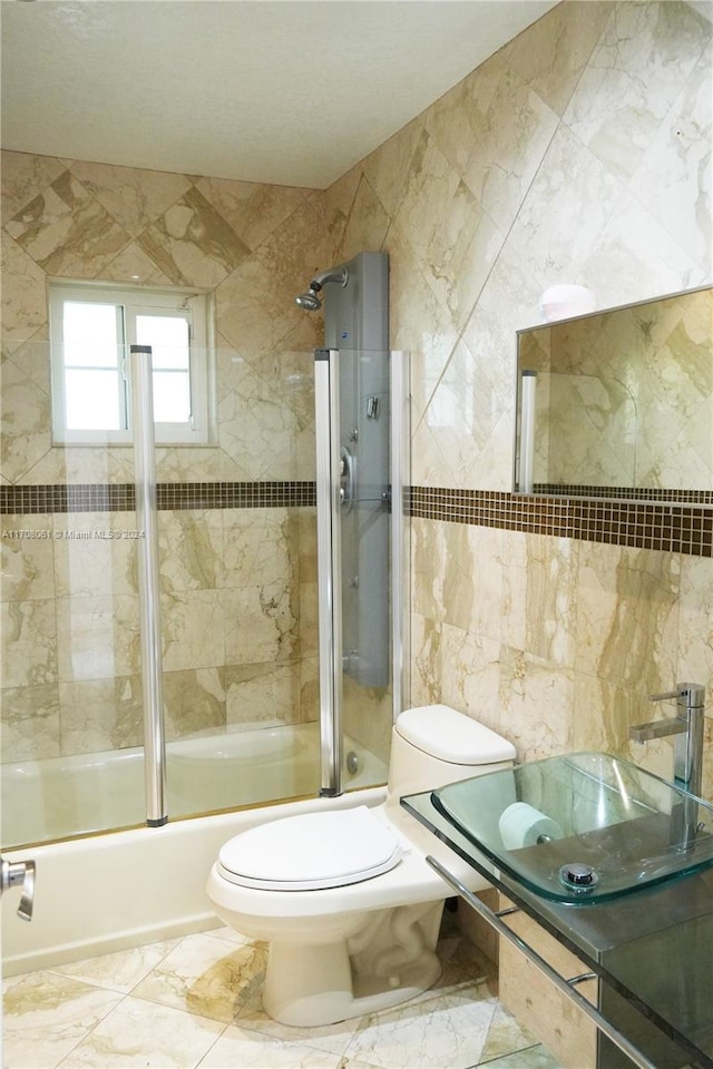 full bathroom featuring sink, toilet, tile walls, and enclosed tub / shower combo