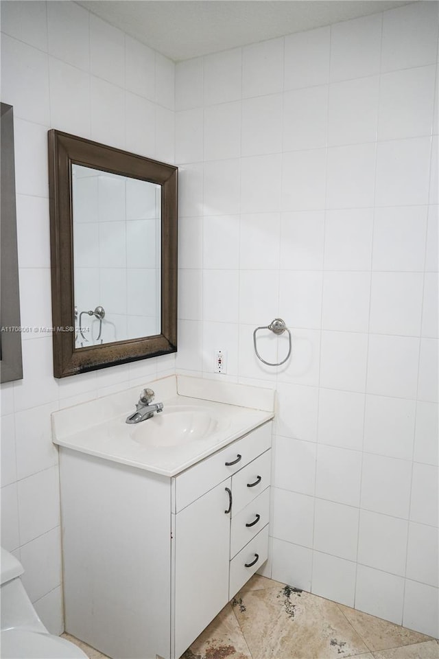 bathroom with vanity and tile walls