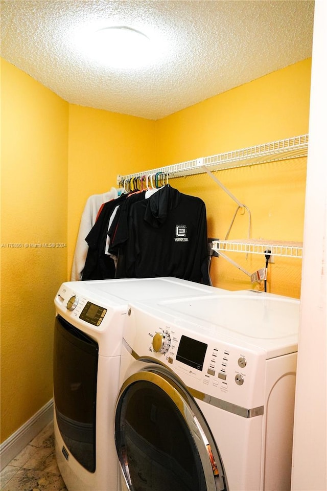 washroom featuring washer and dryer and a textured ceiling