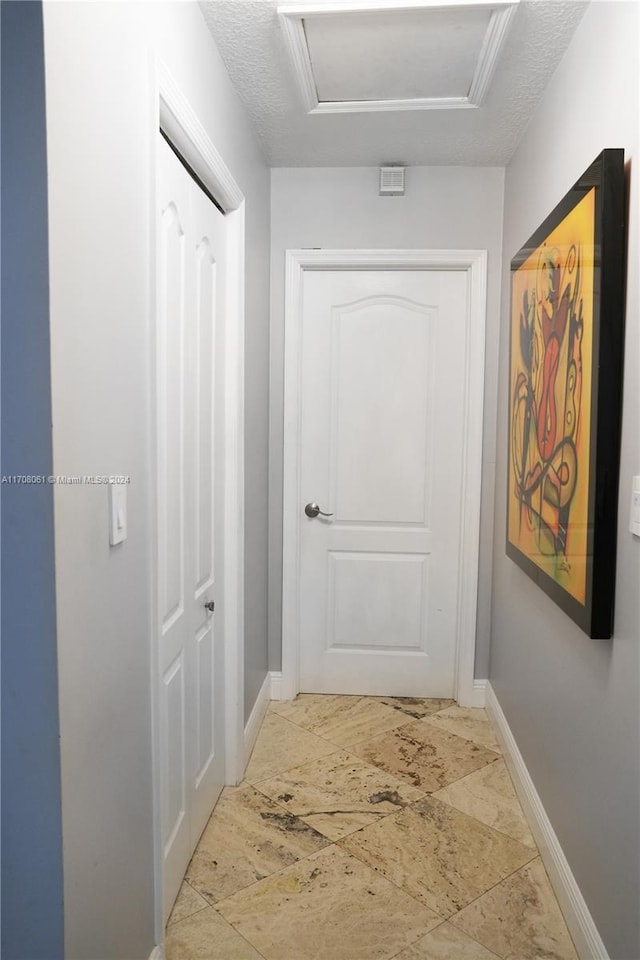 hallway with a textured ceiling