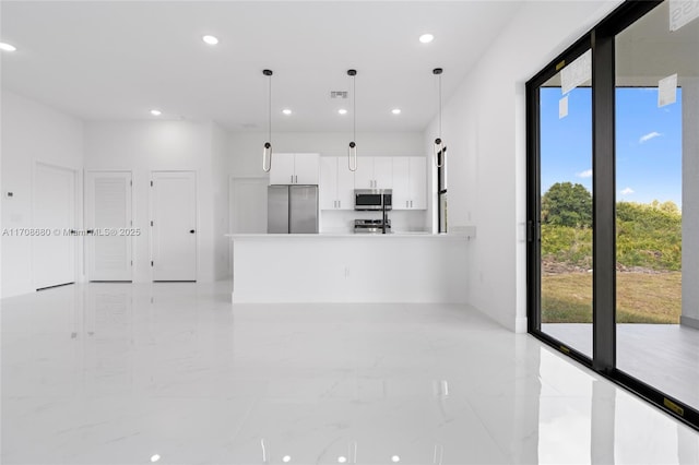 interior space with white cabinets, marble finish floor, light countertops, appliances with stainless steel finishes, and hanging light fixtures