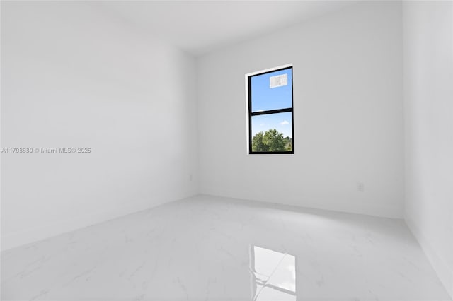 spare room featuring marble finish floor