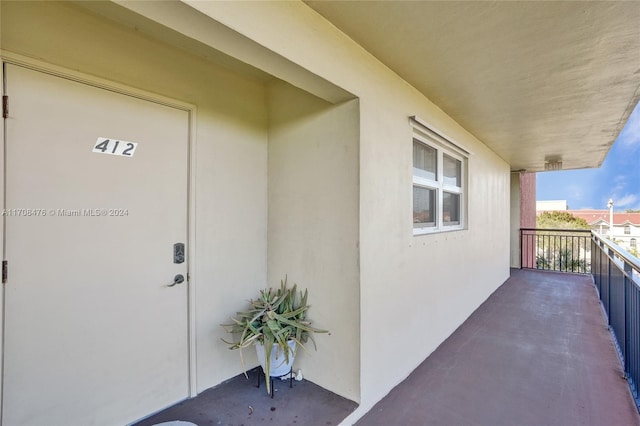 view of exterior entry with a balcony