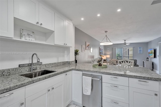 kitchen featuring kitchen peninsula, light stone countertops, ceiling fan, sink, and white cabinetry