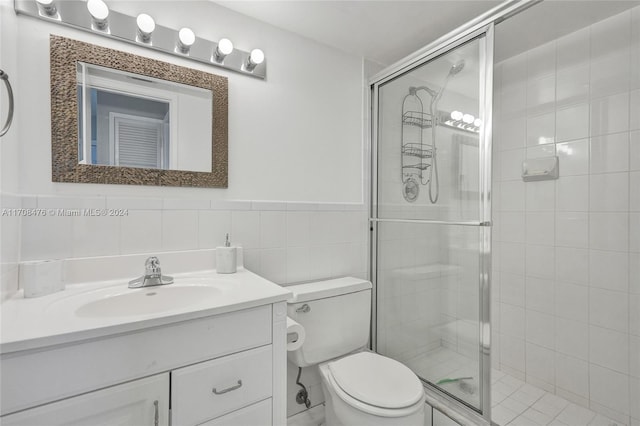 bathroom with an enclosed shower, vanity, toilet, and tile walls