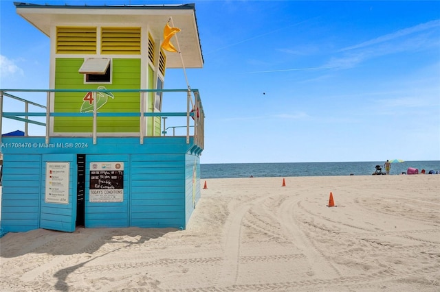 view of property's community with a water view and a beach view