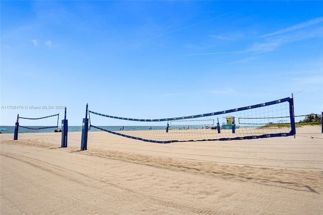 surrounding community with volleyball court and a water view