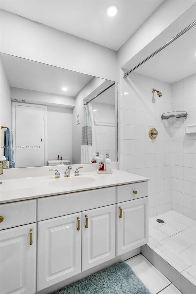 bathroom featuring tile patterned flooring, vanity, and walk in shower
