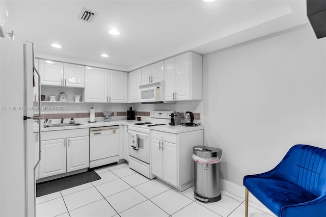 kitchen with white appliances, sink, decorative backsplash, light tile patterned floors, and white cabinetry