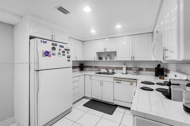 kitchen featuring white cabinets, white appliances, tile counters, and sink