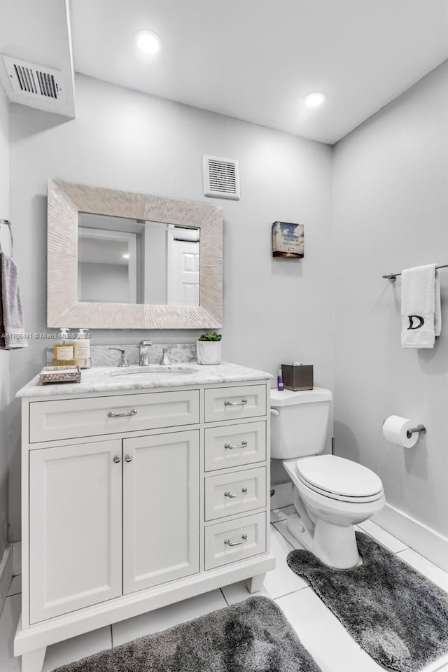 bathroom with tile patterned flooring, vanity, and toilet